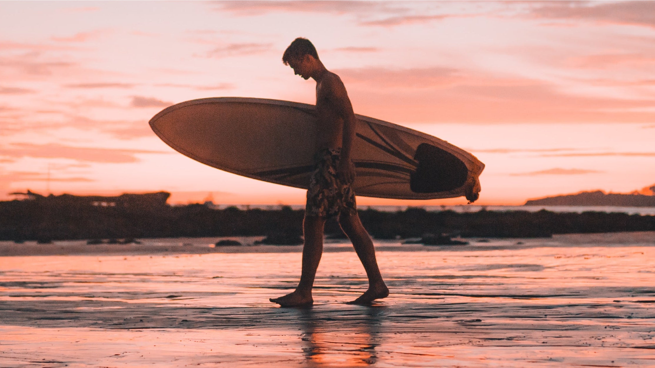 Man wearing quick-dry men's swim trunks walking from the beach to a seaside café