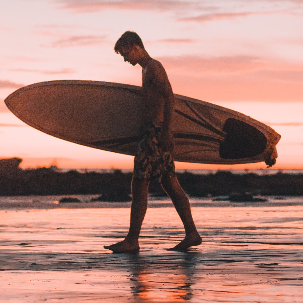 Man wearing quick-dry men's swim trunks walking from the beach to a seaside café