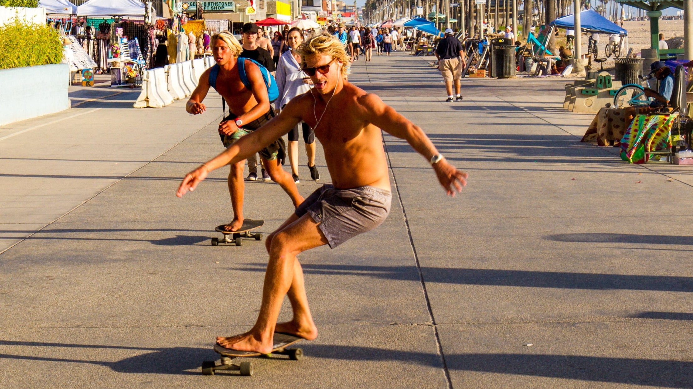 Man wearing quick-dry men's swim trunks while walking from the beach to the city in summer 2025