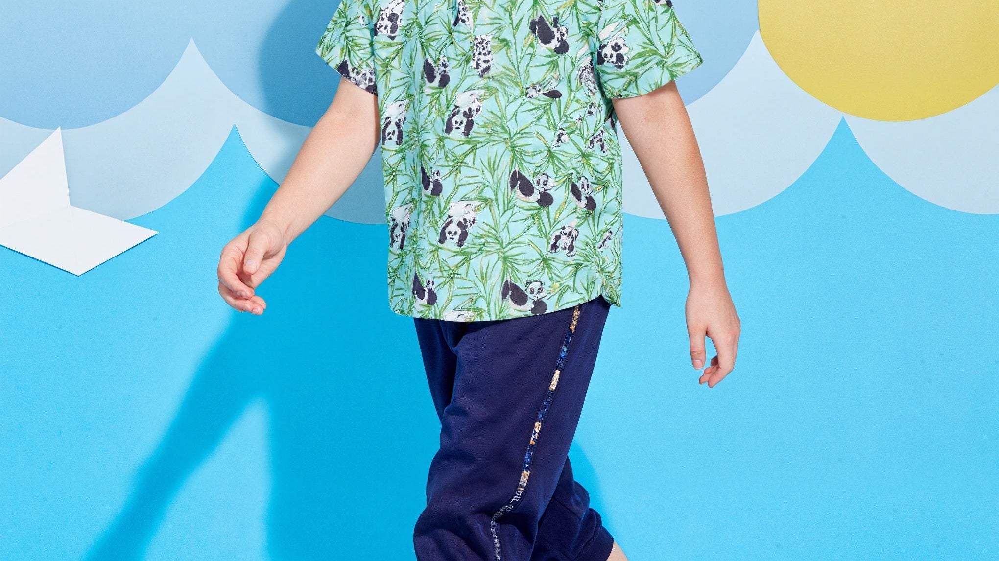 Child wearing a Surfcuz Hawaiian shirt with palm tree pattern, ideal for summer vacations