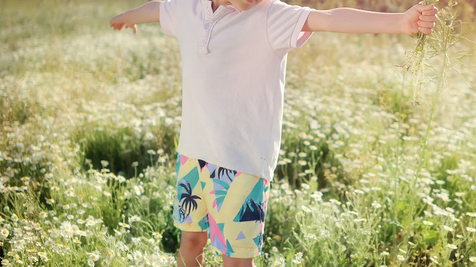 Happy child wearing Surfcuz kids swim trunks at the beach, showing comfort, style, and versatility for summer play.