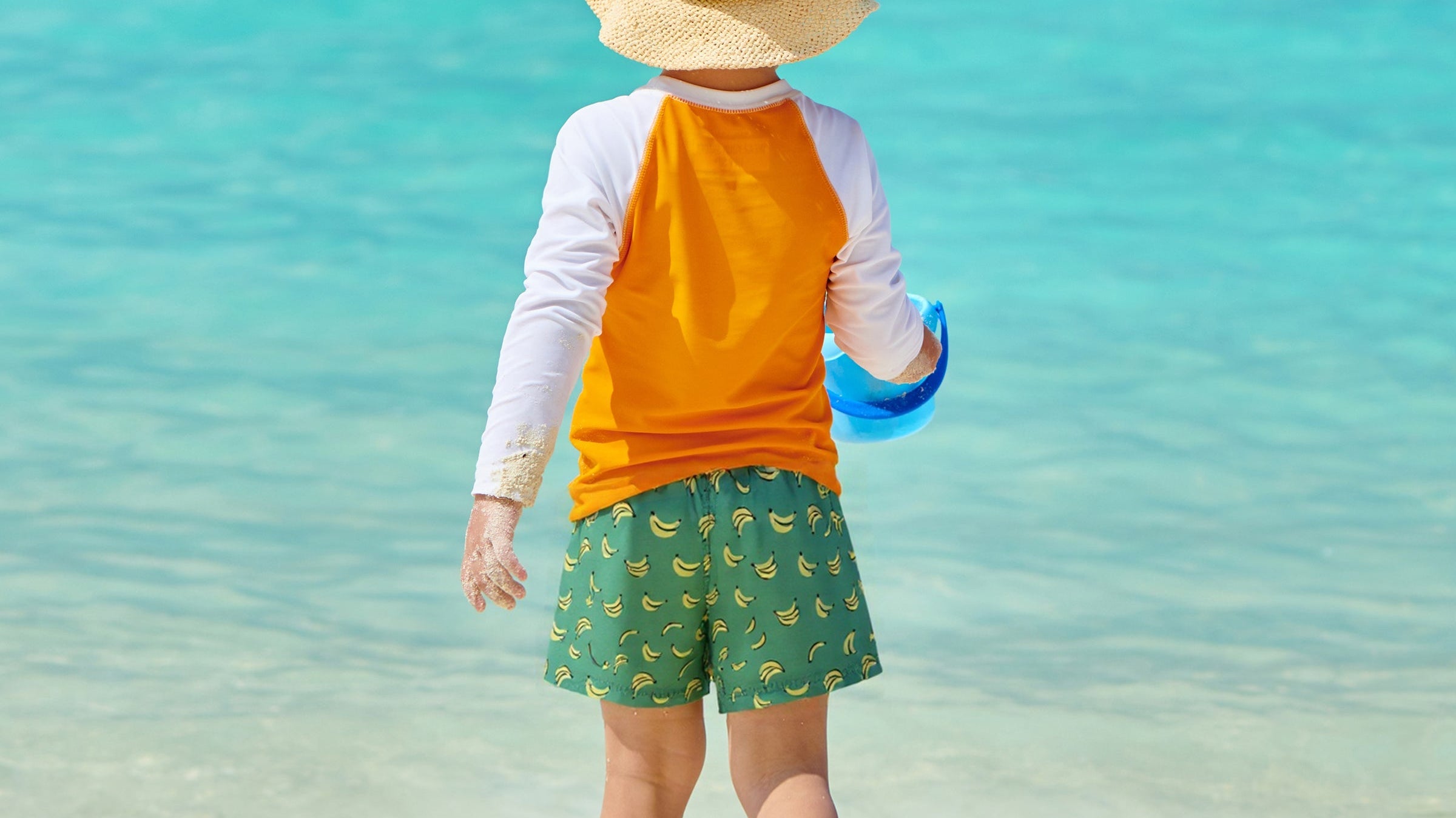 Boys wearing Surfcuz holiday swim shorts on the beach — quick-dry, 4-way stretch, perfect for swimming, travel, and family vacations
