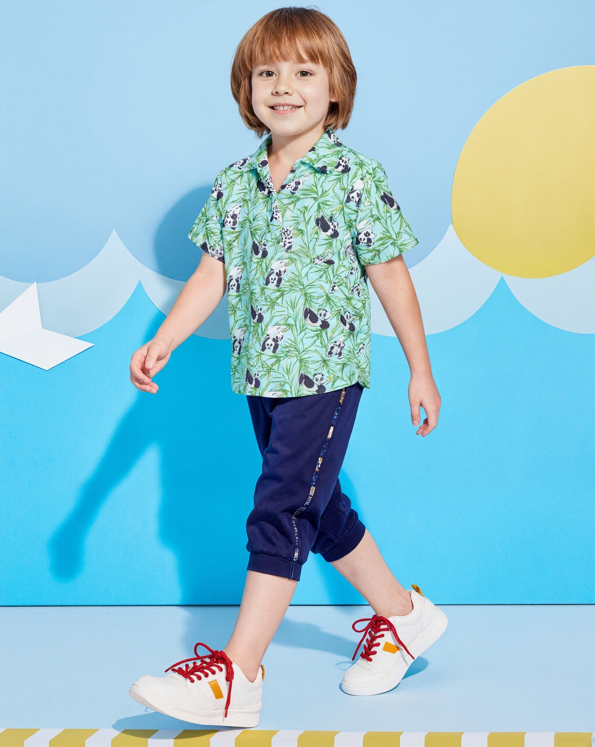 Child wearing a Surfcuz Hawaiian shirt with palm tree pattern, ideal for summer vacations