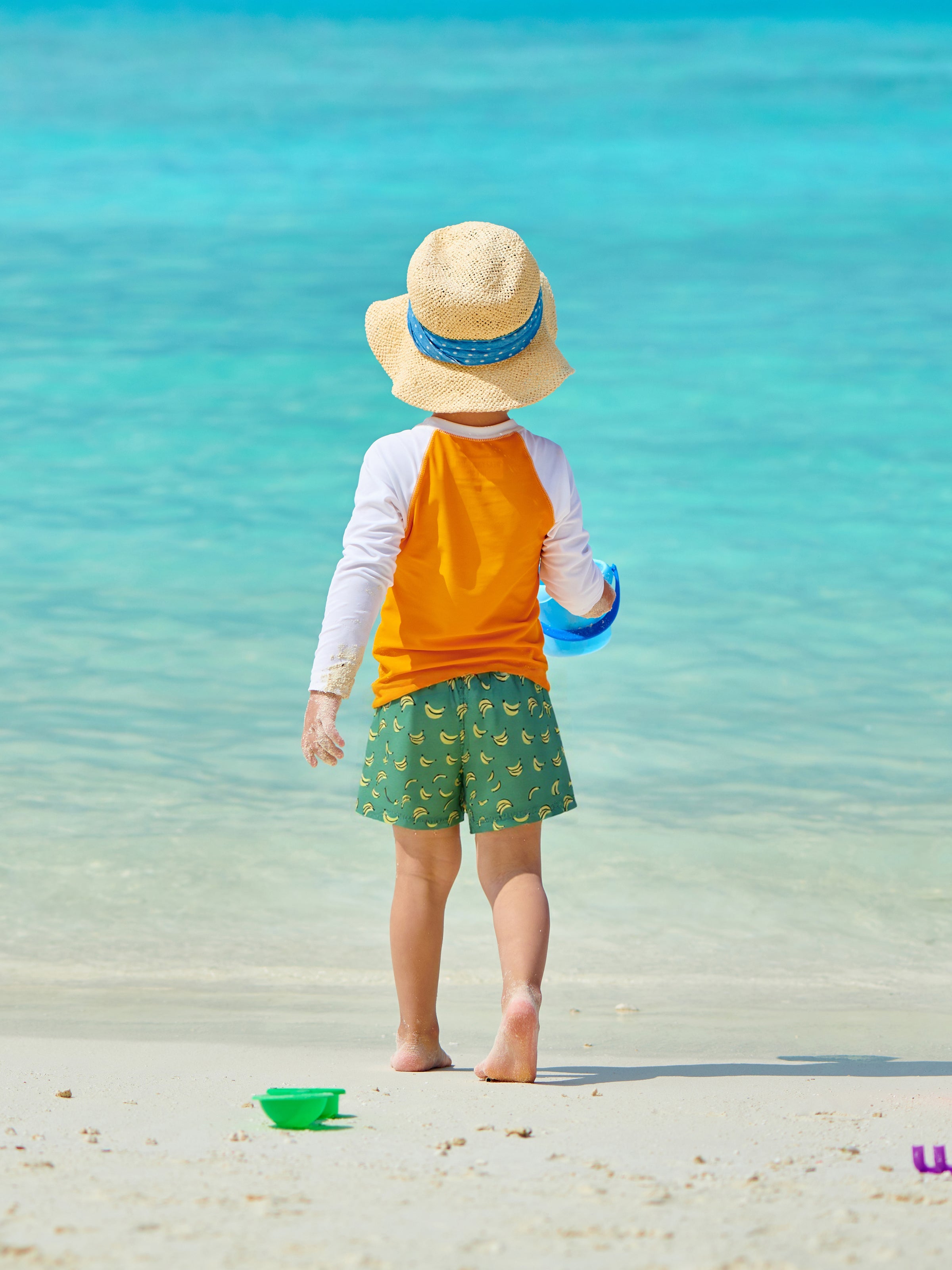 Boys wearing Surfcuz holiday swim shorts on the beach — quick-dry, 4-way stretch, perfect for swimming, travel, and family vacations